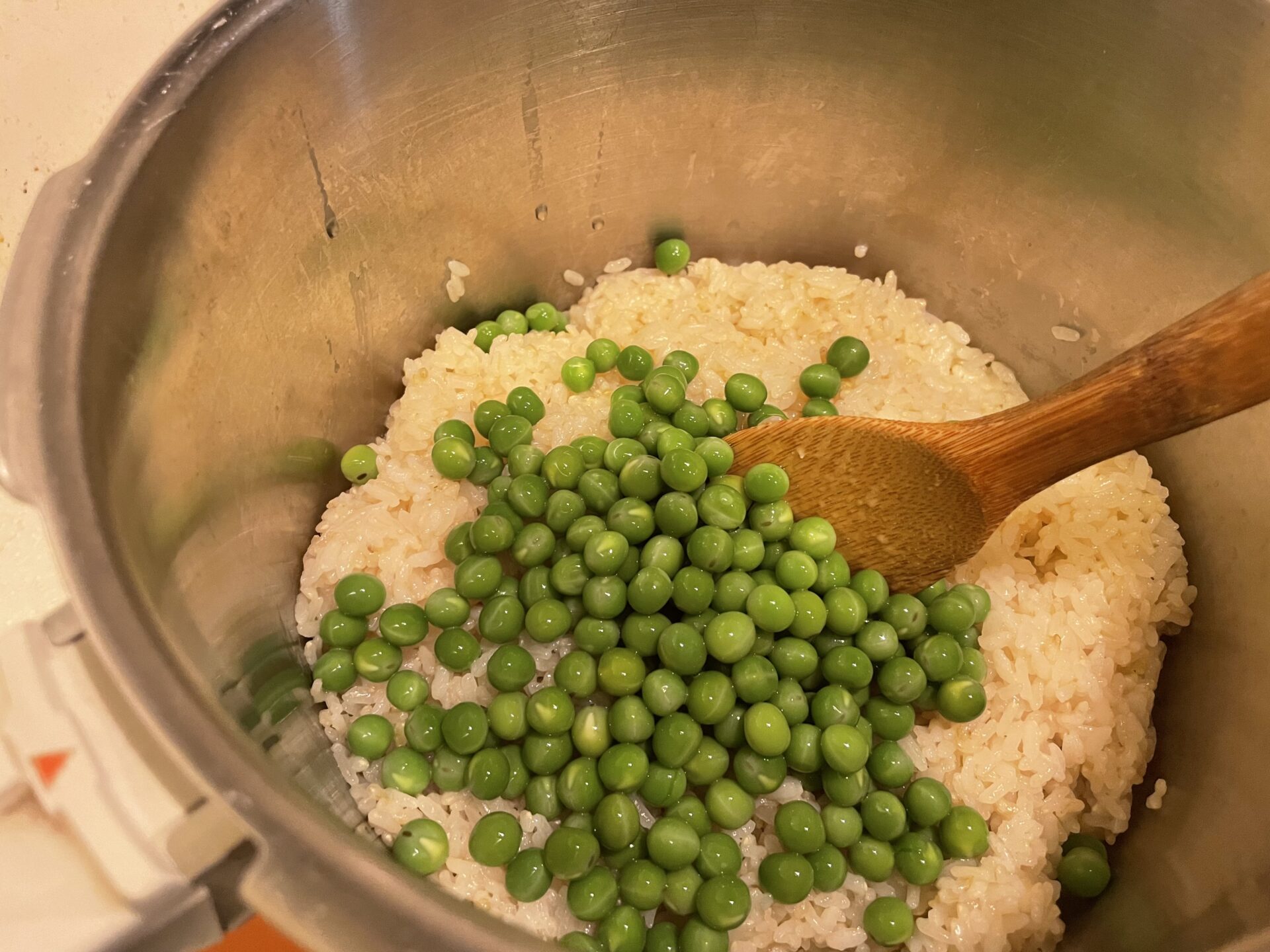 炊き上がったご飯にうすいえんどう豆を混ぜる